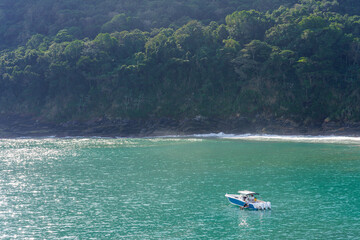 lancha ancorada na praia com Sol intendo