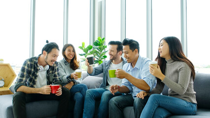 Group of happy creative team talking while taking coffee break at office