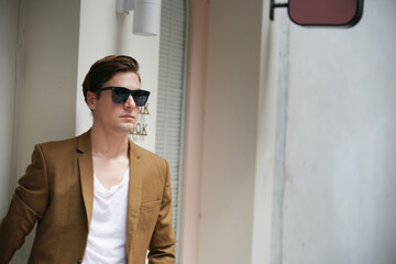 Portrait of a young man with sunglasses standing in urban background