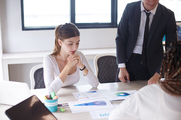 Image of young business people discussing document in paperwork data on desk at meeting