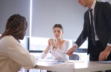 multiethnic female friends, working with computer indoors, telecommuting, young modern people in smart casual wear communicating and using modern technologies while working in the office