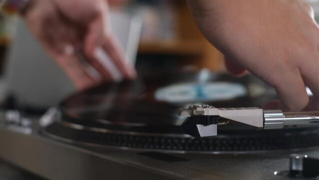 Hand on the Vinyl Record on The Record Player or Turntable and Switch on The Turntable 
