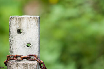 Rusty chains that tie on cement pillars.
