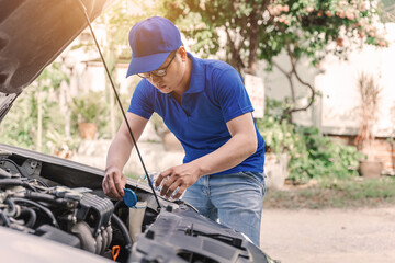 Close up Asian auto mechanic working in garage. Repair service.