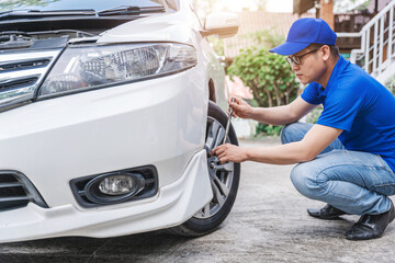 Close up auto mechanic man checking car tire . Car service. Hands replace tires on wheels. Tire...
