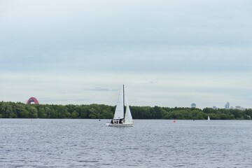 a white boat without a sail in the summer on the lake. white boat on the pier