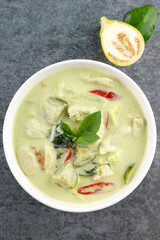Green curry with chicken, chili, eggplant on a gray background, macro. A popular Thai dish is Kaeng kheow hwan. AT