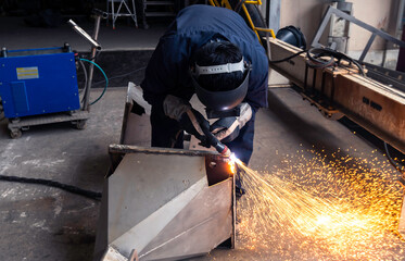  Metal cutting with plasma. cutting steel with sparks. Workers wearing industrial uniforms and...