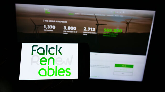 Stuttgart, Germany - 01-16-2022: Person holding cellphone with logo of Italian energy company Falck Renewables S.p.A. on screen in front of webpage. Focus on phone display.