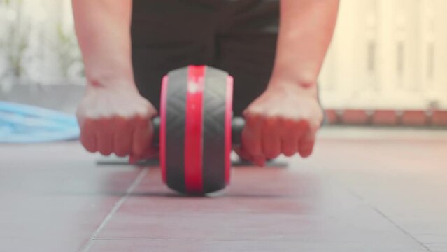 Exercise with an abdominal exercise roller. Exercise equipment to reduce belly fat, build six-packs and strong muscles.
