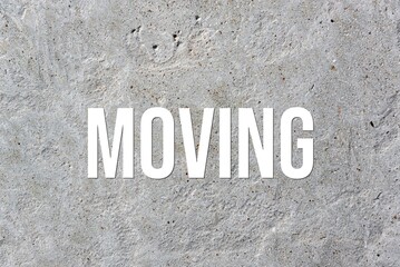 MOVING - word on concrete background. Cement floor, wall.