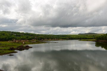Rain filled monsoon clouds over a lake in the Indian countryside
