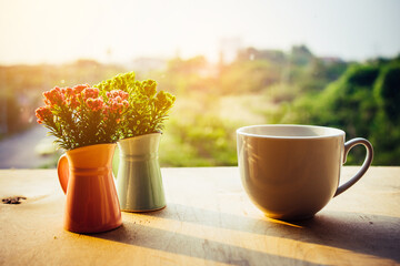 flowers in a vase and cup of coffee on the rustic style background