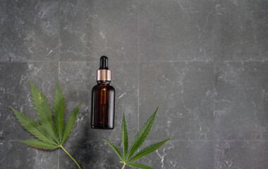 glass bottle with CBD oil, THC tincture and hemp leaves on a marble background. Flat lay, minimalism. Cosmetics CBD.