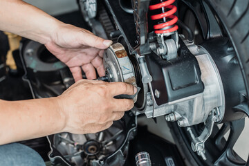 Motorcycle mechanic cleaning clutches with sandpaper. check the condition of Auto Transmission...