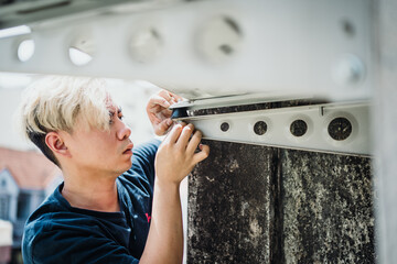 A professional electrician man is fixing Rubber Shock Absorber Vibration Isolator Mounts for Air...