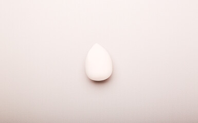 sponge for makeup on a beige background. Beauty concept, top view