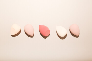 make-up sponges on a beige background. beauty concept, top view
