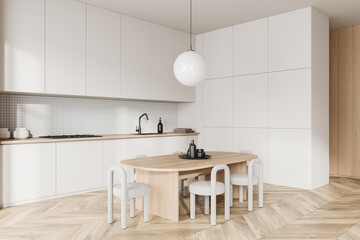 Light kitchen interior with eating table and chairs, kitchenware