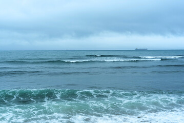 Nature background with sea waves hitting the sea shore. Scenic view of sea against cloudy sky