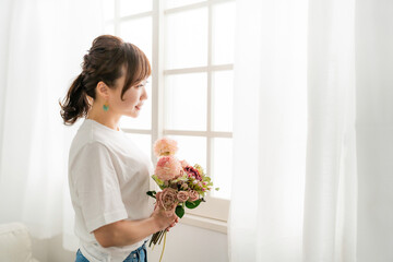 贈り物の花束を持つ日本人女性の横顔（母の日・プレゼント）
