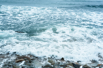 Nature background with sea waves hitting the sea shore. Scenic view of sea against cloudy sky