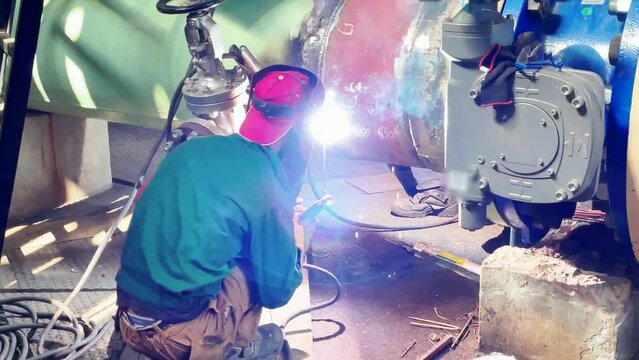 Welder performing an electrode welding of a 600 mm water pipe, slow motion 1