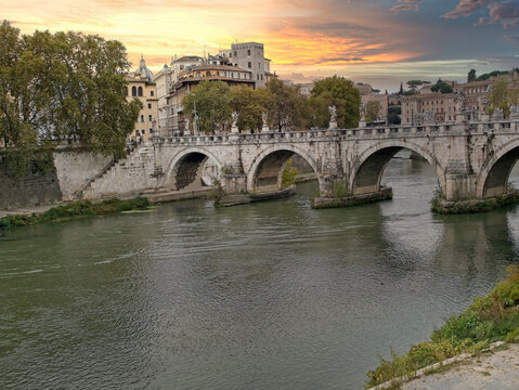 The Tiber river flows along with trees in sunny day, Rome, Italy.