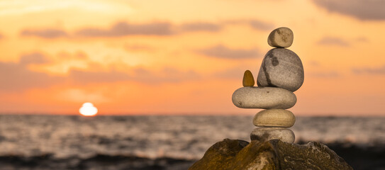 Zen style balancing stones in the evening sun by the sea