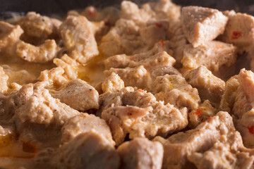 Chicken slices being friend in a pan on a wooden background