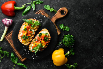 Vegan Sandwich with sweet peppers, cheese, vegetables and basil. Bruschetta. Top view. On a stone background.