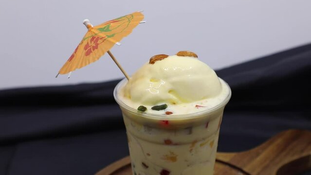 Falooda / Faluda is a popular Indian dessert - some flavored which has Ice cream, noodles, sweet basil seeds and nuts, clip/footage