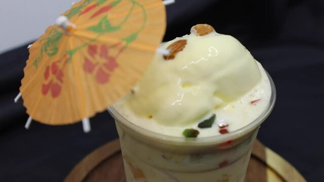 Falooda / Faluda is a popular Indian dessert - some flavored which has Ice cream, noodles, sweet basil seeds and nuts, clip/footage