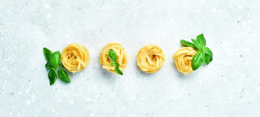 Dry pasta on a gray stone background. Top view. Free space for text.