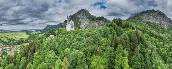 Bavarian Castle embedded in green forest and mountains 