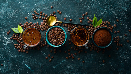 Two cups of fragrant coffee and coffee beans on a black stone background. Top view. Free space for text.
