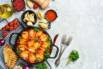 Pasta stuffed with meat, tomatoes and parmesan. In a frying pan. Italian traditional cuisine. Recipe.