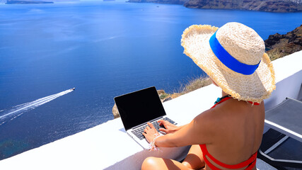 Back view of digital nomad woman freelancer as running remotely with bright scenic view of the...