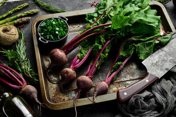 Cooking. Red beets with young leaves on a kitchen background. Rustic style.