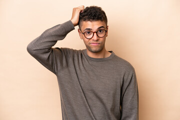 Young Brazilian man isolated on beige background with an expression of frustration and not...