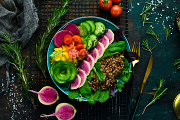 Balanced food: Quinoa, watermelon radish, cucumber, tomatoes and spinach. Buddha bowl tasty food concept on stone background.