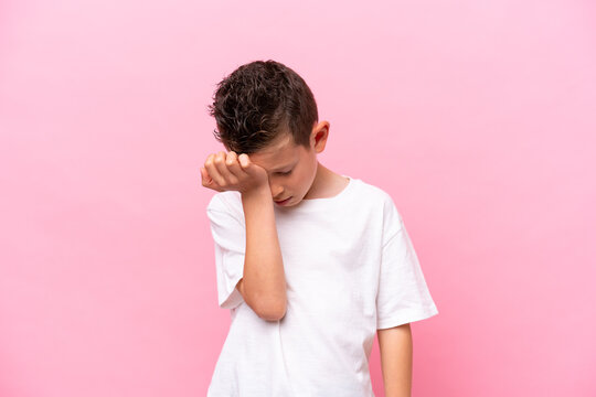 Little caucasian boy isolated on pink background with headache