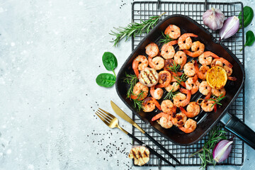 Grilled prawns grilled with lemon and garlic. On a stone background.