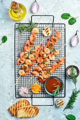 Grilled shrimps on skewers with lemon and garlic. Seafood. On a stone background.