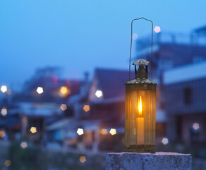 Vintage lamp with candle inside over blurry hostel background with pentagon bokeh