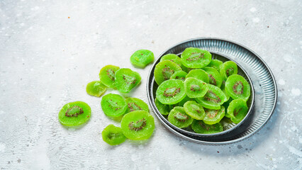 Candied kiwi. Dried fruits. On a stone background.