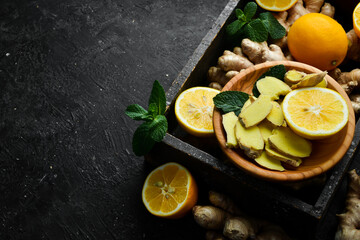 Fresh ginger, mint and lemon on a black background. Top view. On a stone background.