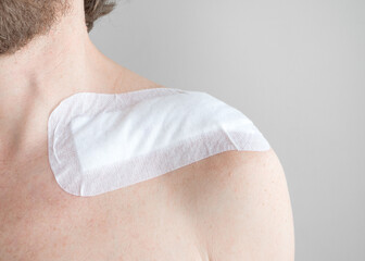 large size band aid on a scar after surgery for a fractured clavicle on the male body 