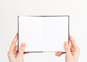 female hands hold an open lined notebook with blank white pages. education, business concept