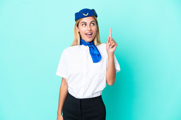Airplane stewardess Uruguayan woman isolated on blue background thinking an idea pointing the finger up